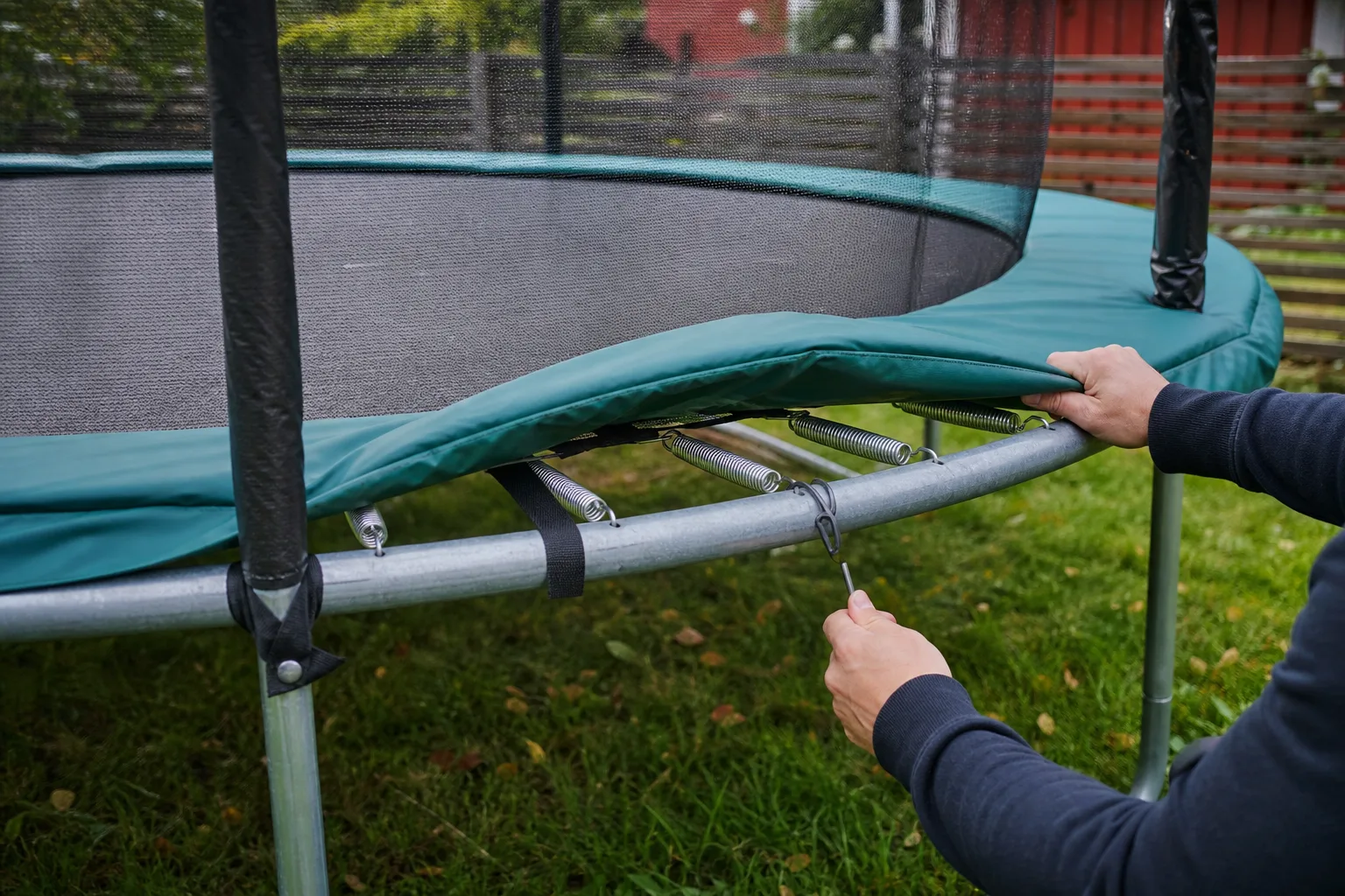 Grönt kantskydd som täcker fjädrarna på en studsmatta