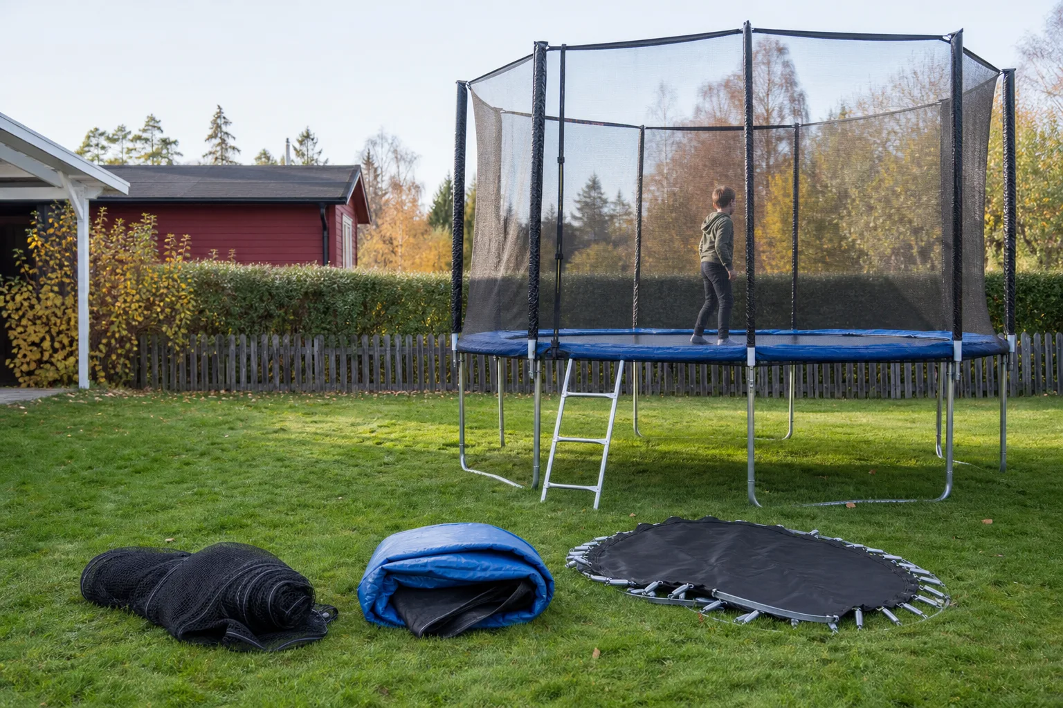 Studsmatta med kantskydd och nät inför översyn i trädgården