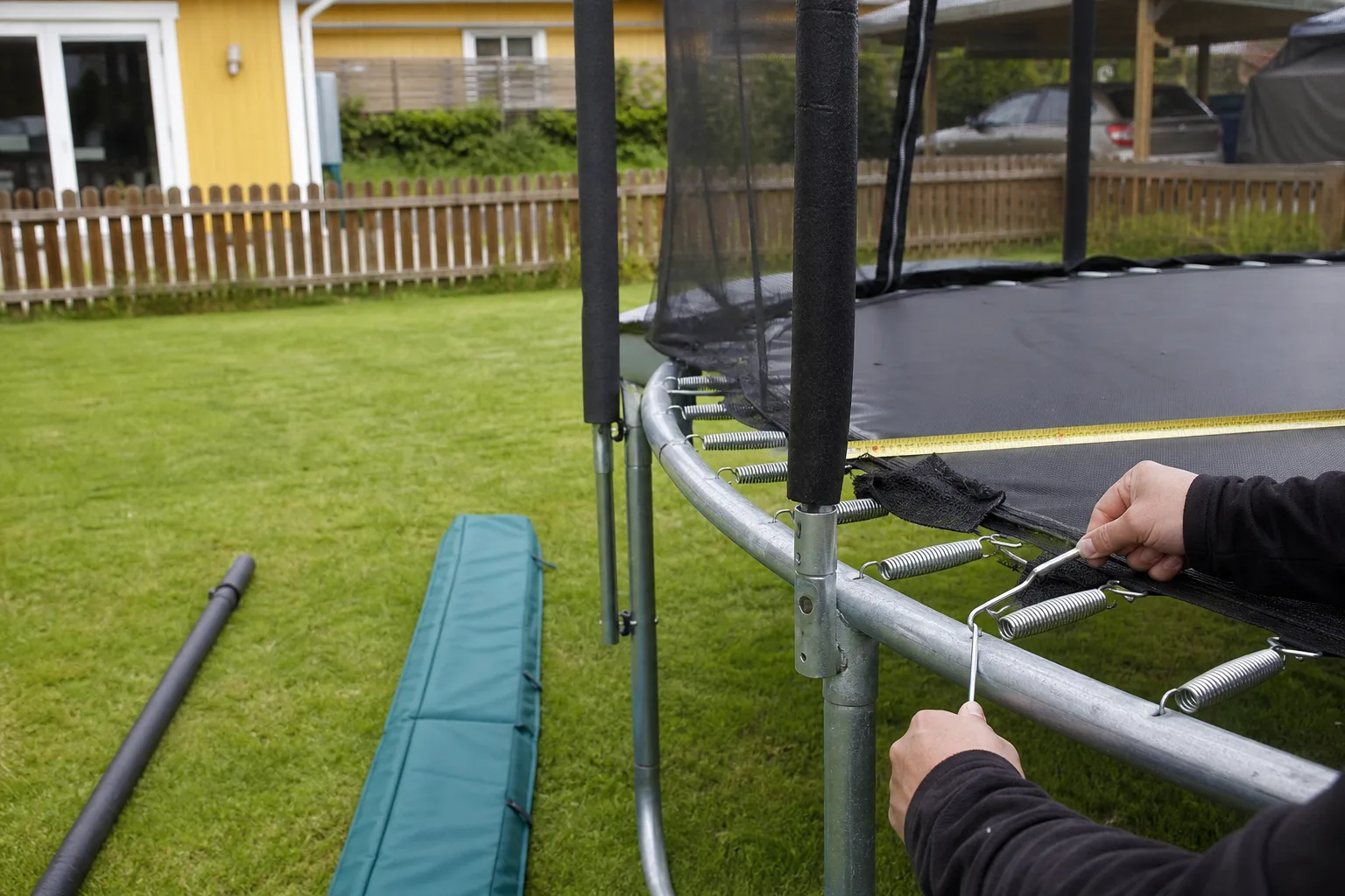 Nätstolpe och kantskydd intill studsmattans ram